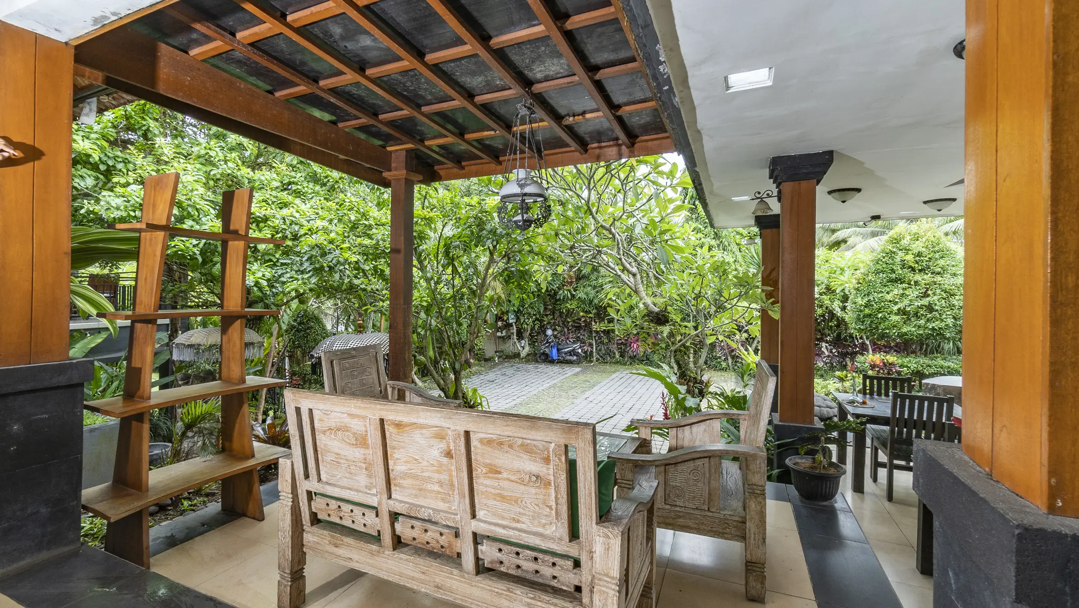 Open-air lounge and dining area surrounded by tropical greenery at Gita Maha Hotel